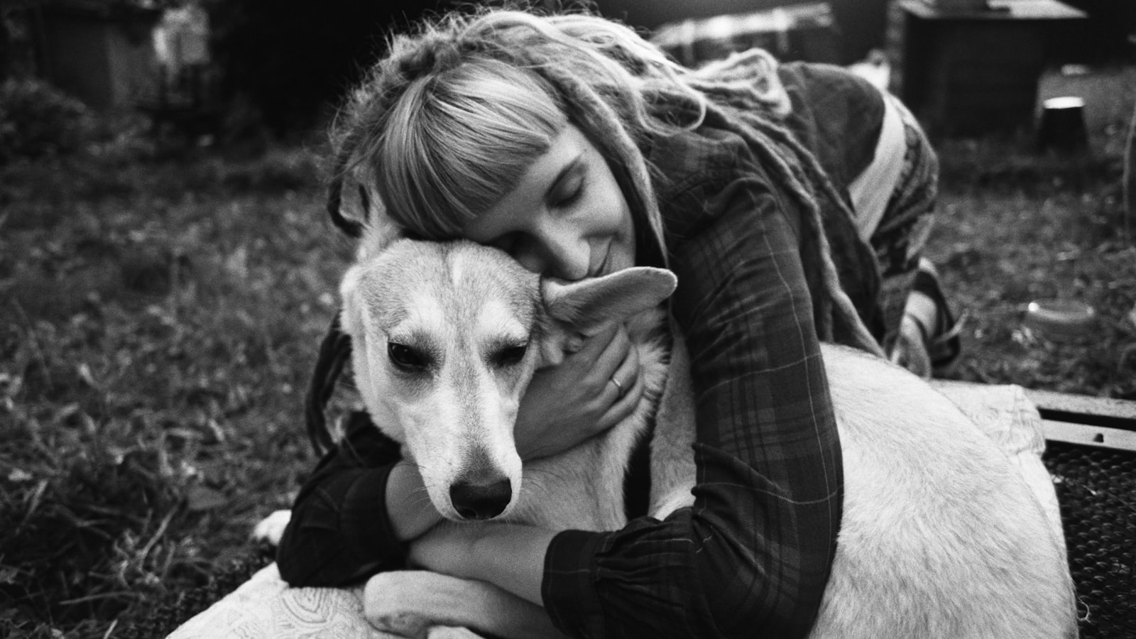 grayscale photo of woman hugging dog