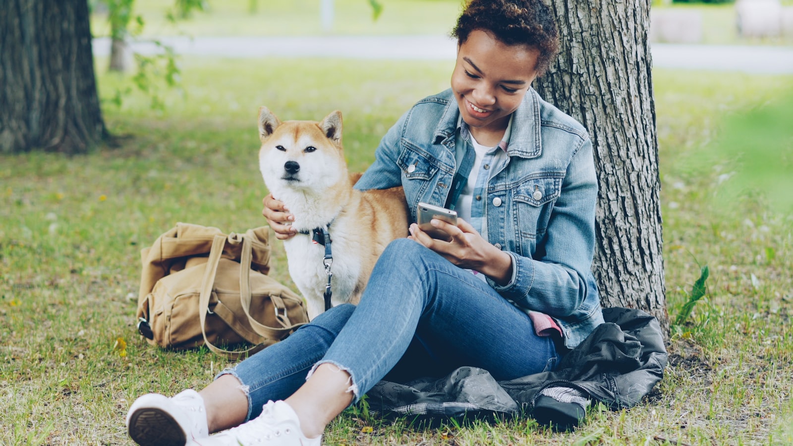 Woman enjoys park with her shiba inu.