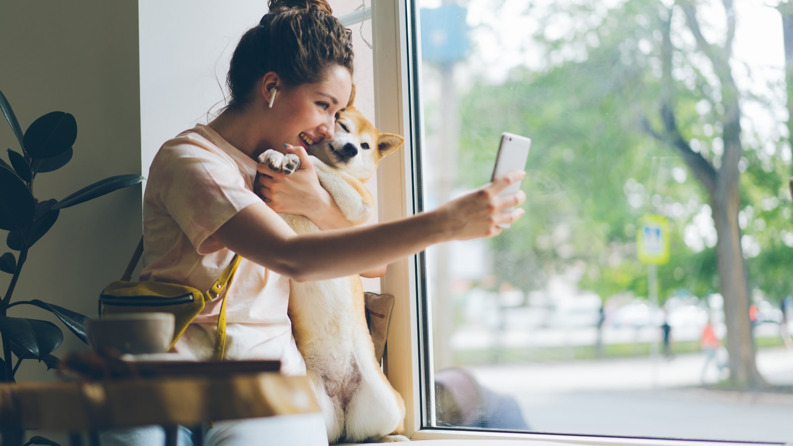 a woman looking at her cell phone while holding a dog
